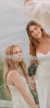 Seaview behind two girls in white enjoy a party