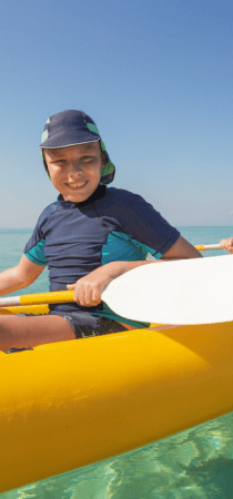 Boy smiles while enjoying sea kayaking in Crete, Greece
